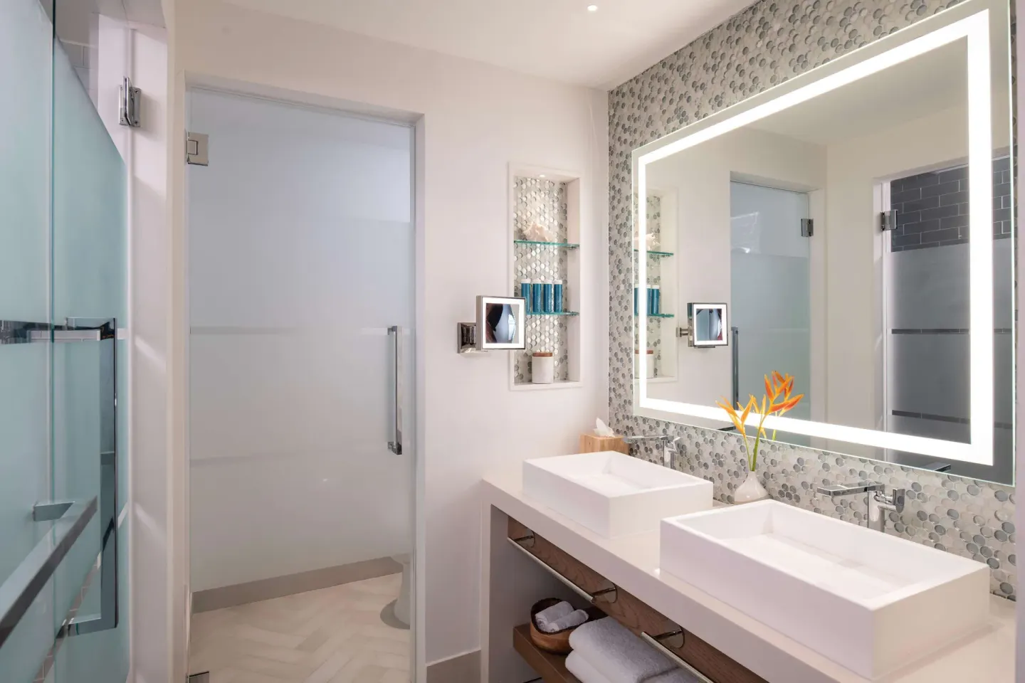 Double vanity bathroom with backlit mirror and shower at Sandals Dunns River.