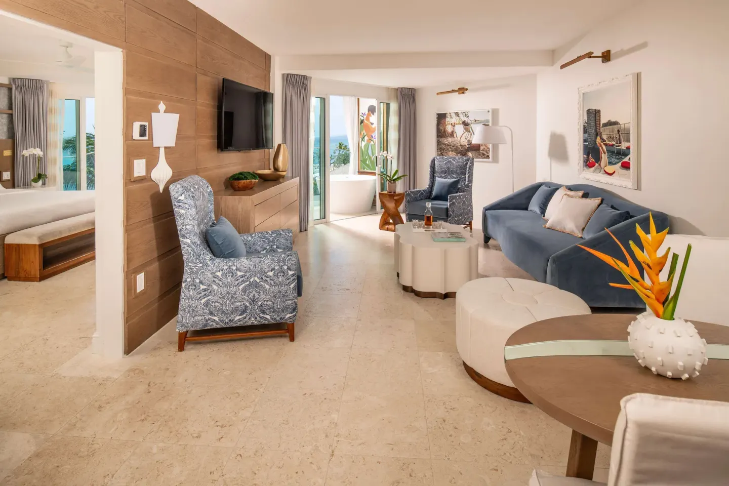 Ocean-view suite living room with blue seating at Sandals Dunns River.