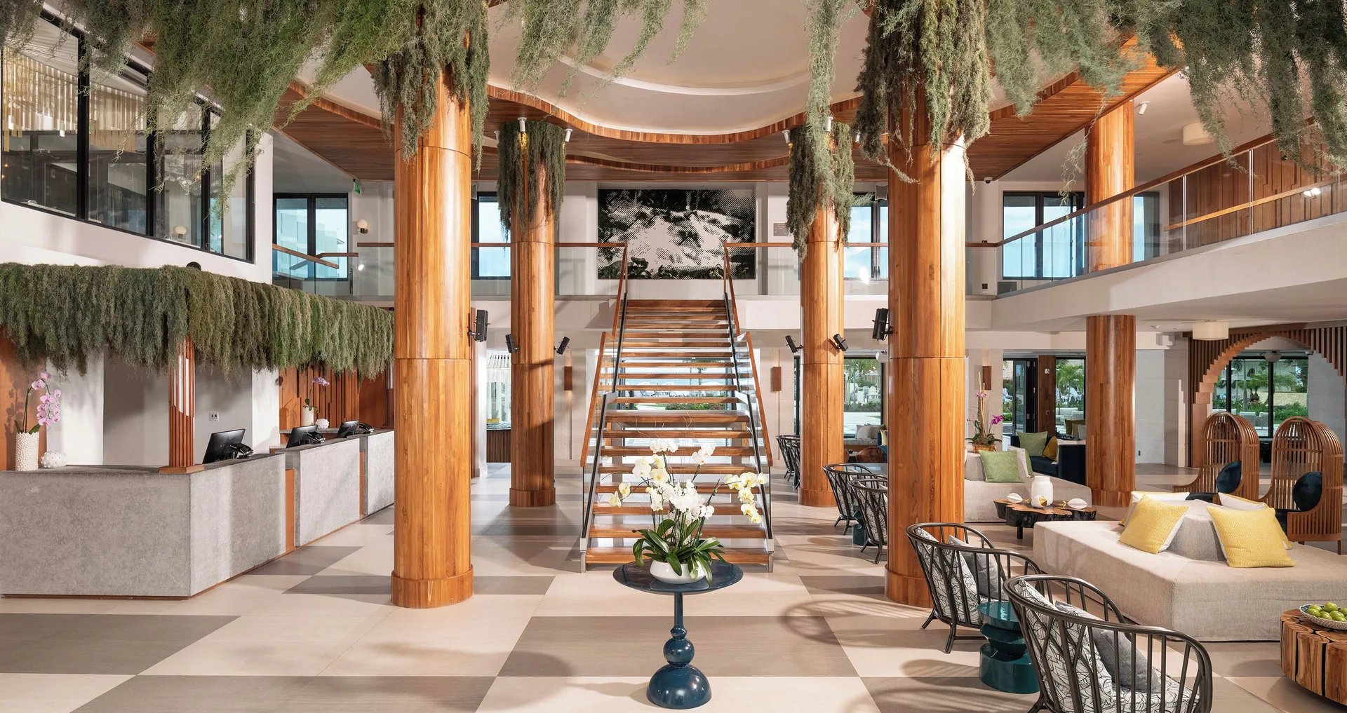 Resort lobby with wood columns and central staircase at Sandals Dunns River.