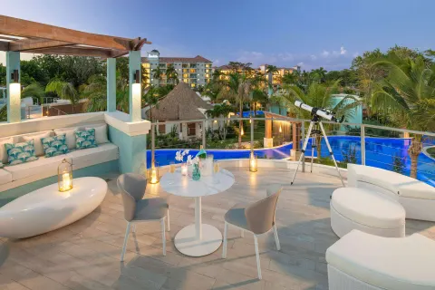 Rooftop terrace with lounge seating and pool views at Sandals Dunns River.