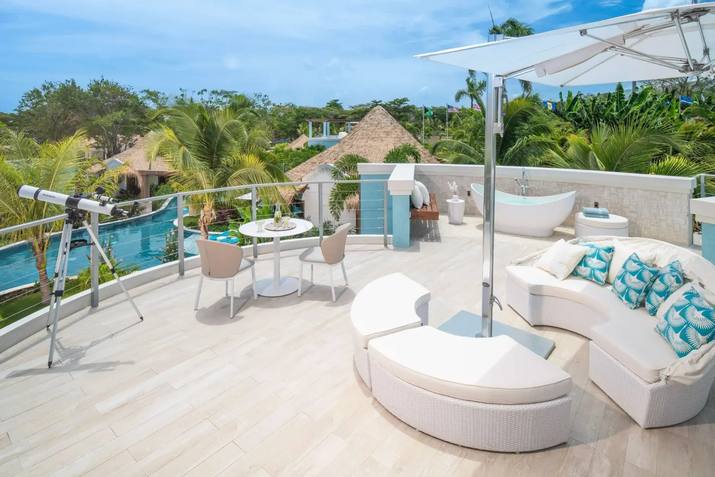 Rooftop terrace with sofa, umbrella, tub, and pool views at Sandals Dunns River.