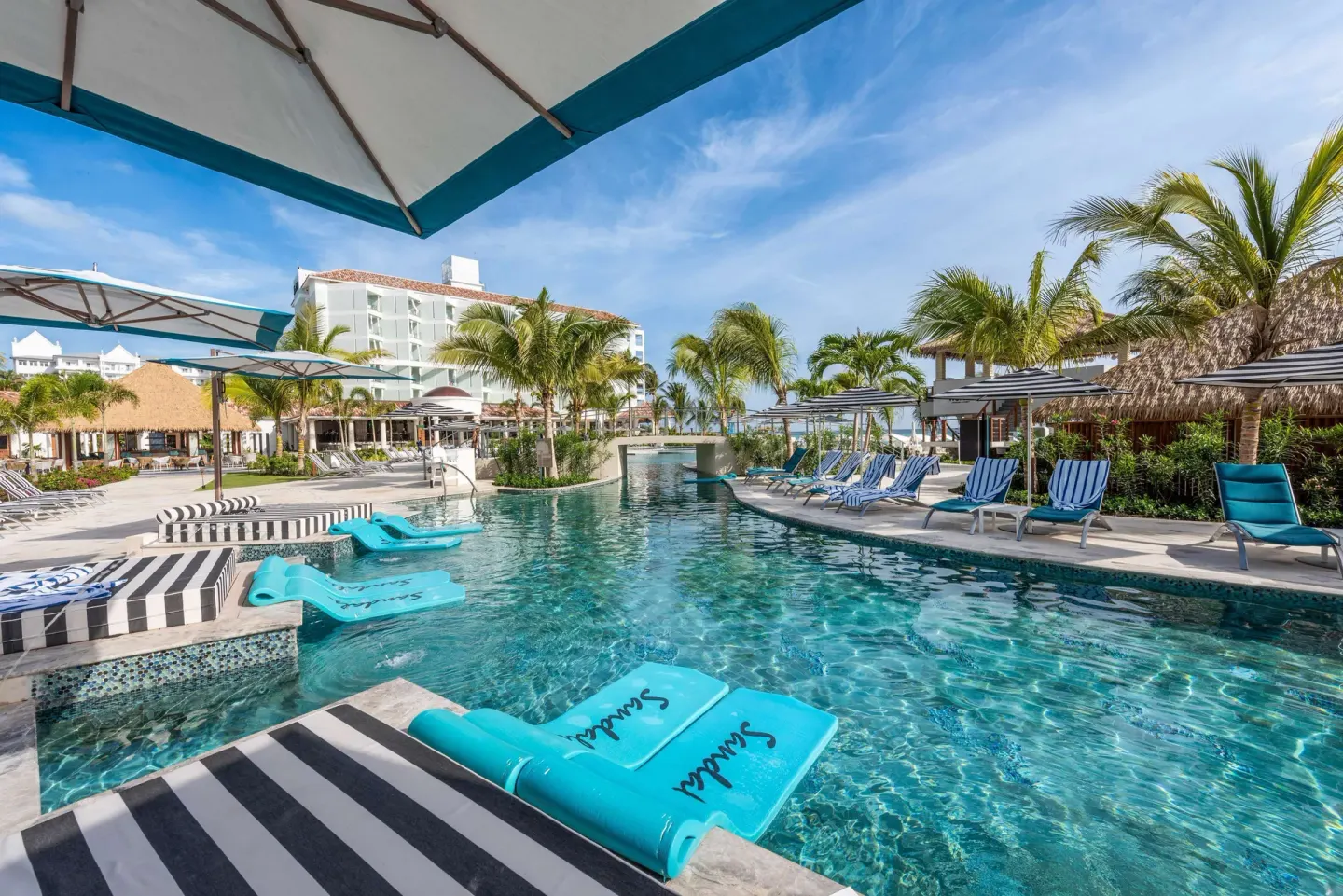 Swim-up pool area with loungers and umbrellas at Sandals Dunns River.