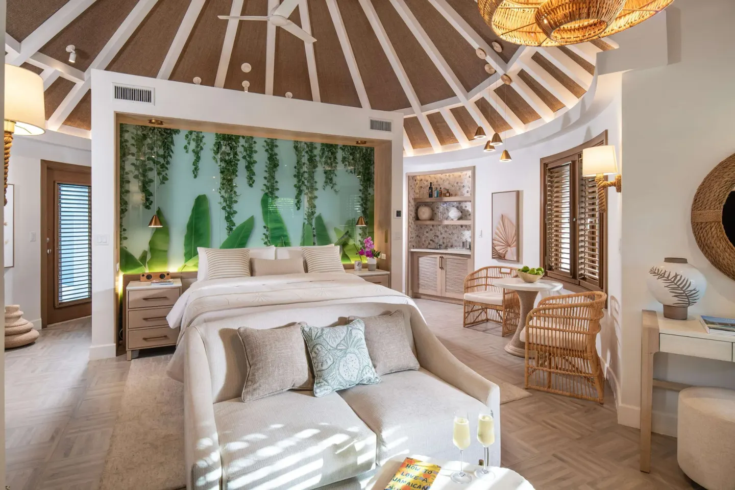 King-bed suite with vaulted ceiling and lounge area at Sandals Dunns River.