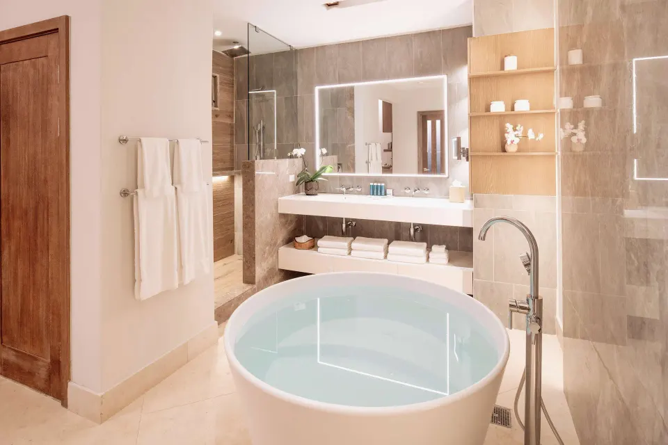 Modern suite bathroom with round tub and double vanity at Sandals Dunns River.