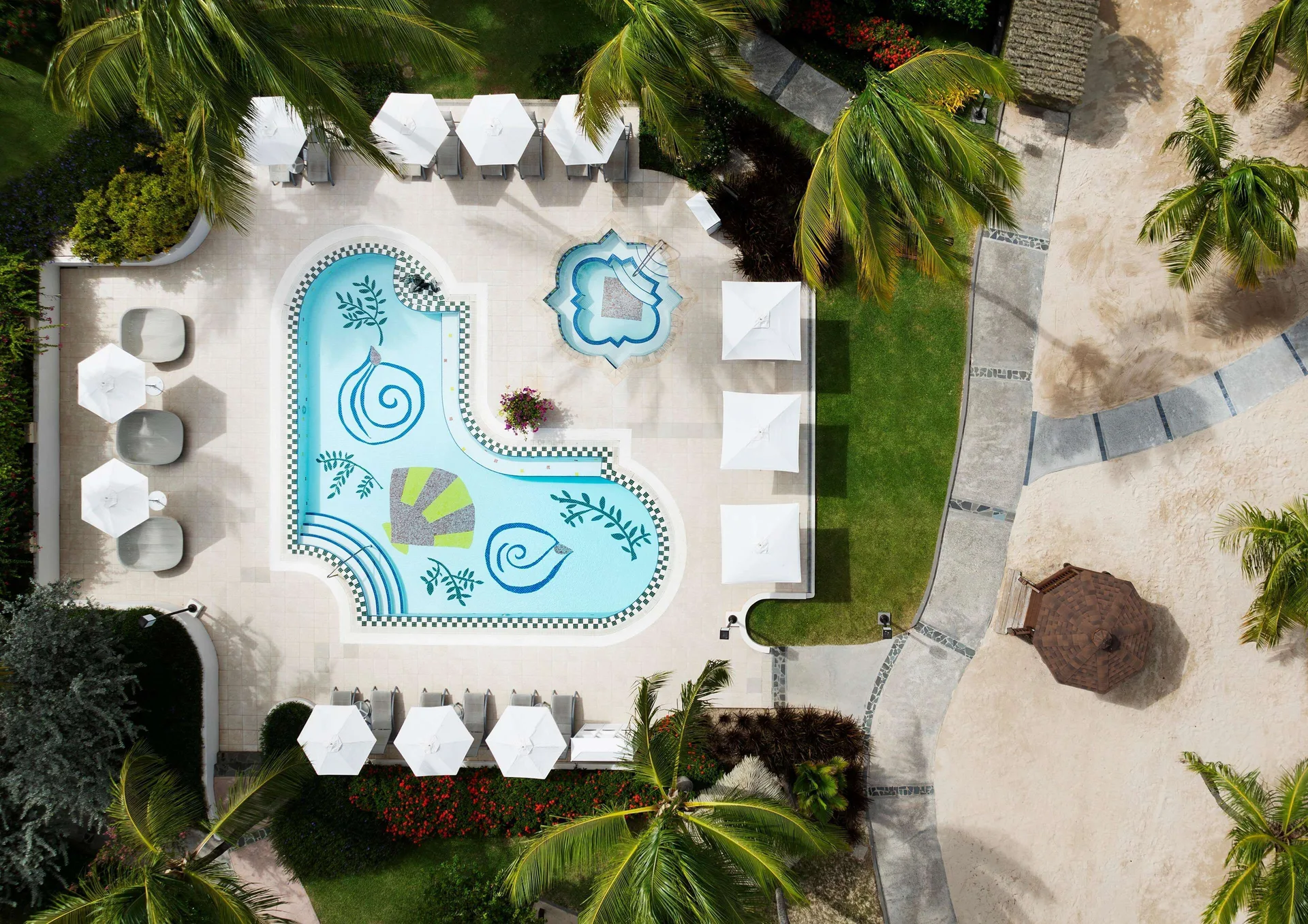 Aerial view of a decorative pool and nearby beach at Sandals Grande St. Lucian.