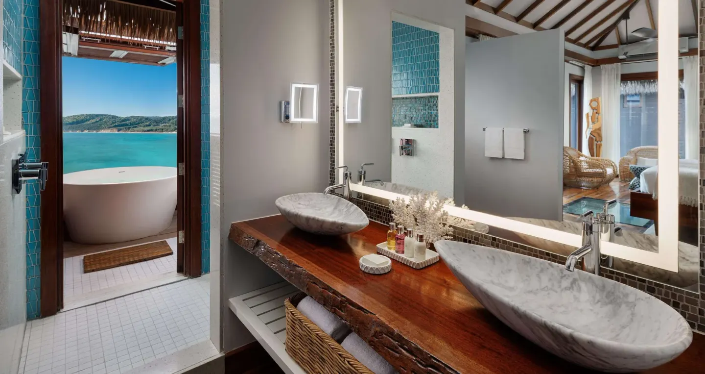 Bathroom vanity with outdoor tub and sea view at Sandals Grande St. Lucian.