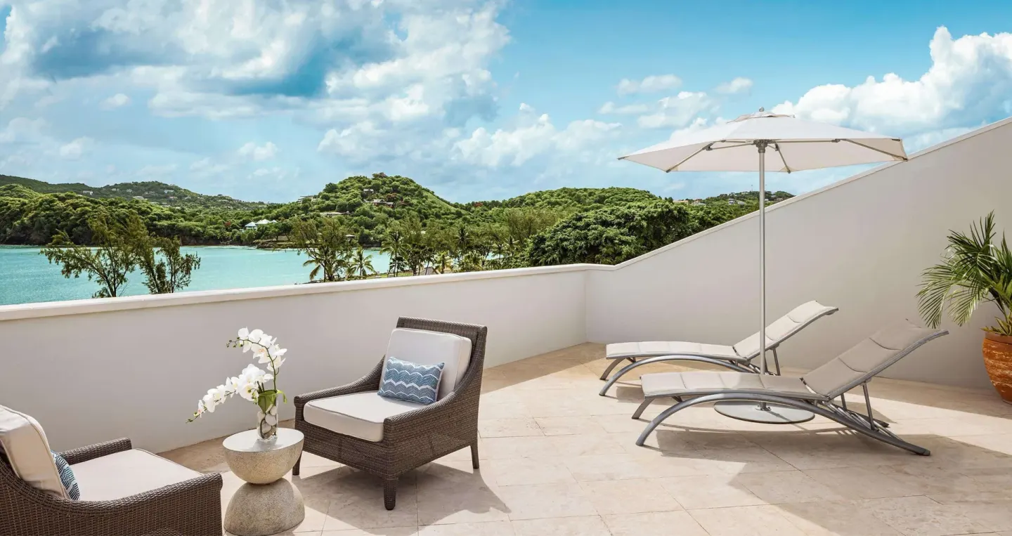 Sun terrace with loungers and bay view at Sandals Grande St. Lucian.