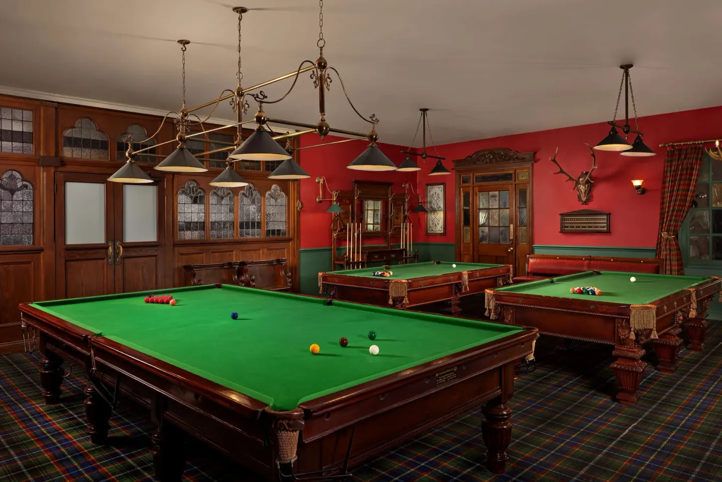 Billiards room with green tables and red walls at Sandals Grande St. Lucian.