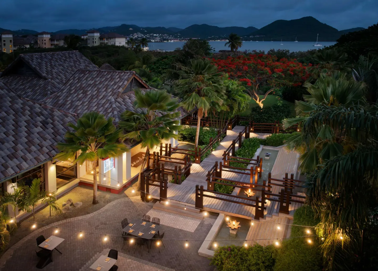 Evening resort grounds with lit walkways and bay views at Sandals Grande St. Lucian.