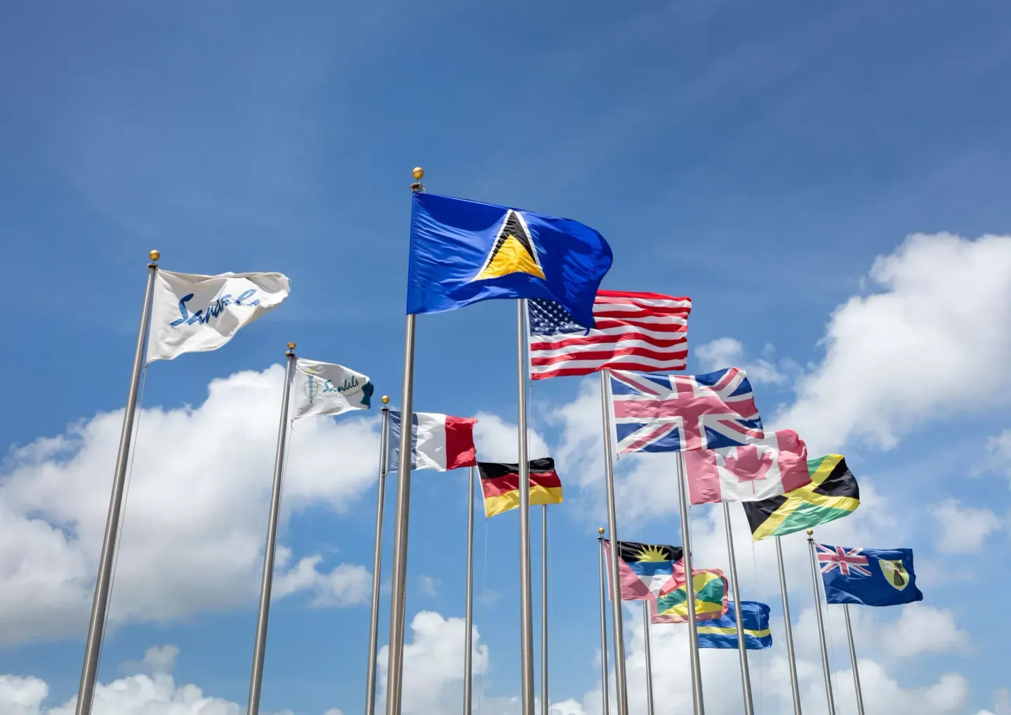 International flags flying under a blue sky at Sandals Grande St. Lucian.