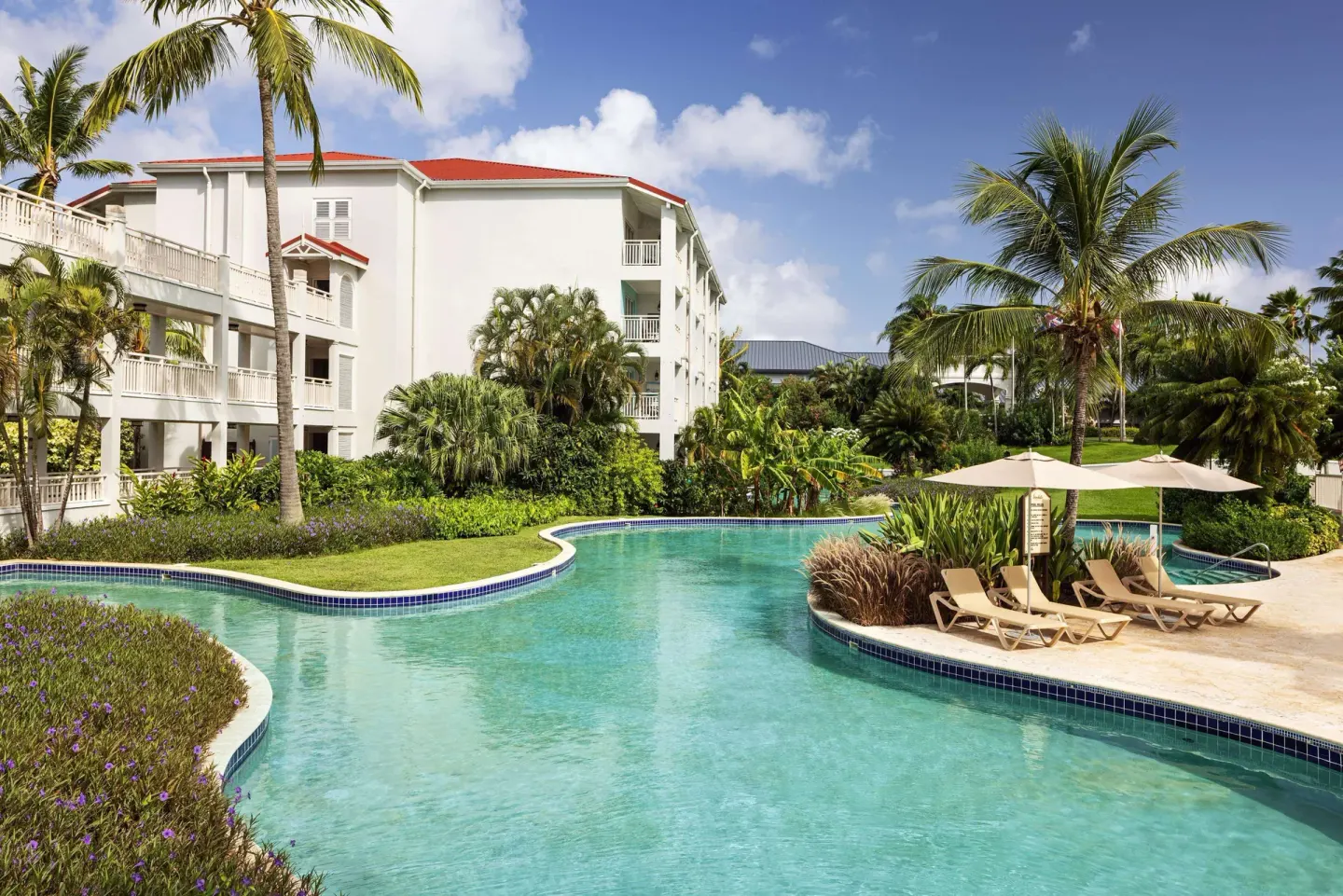Lagoon pool with loungers and resort buildings at Sandals Grande St. Lucian.