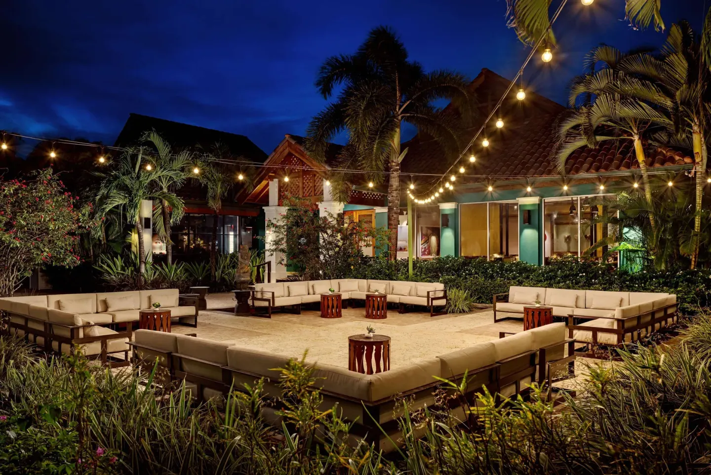 Outdoor lounge courtyard with string lights at Sandals Grande St. Lucian.