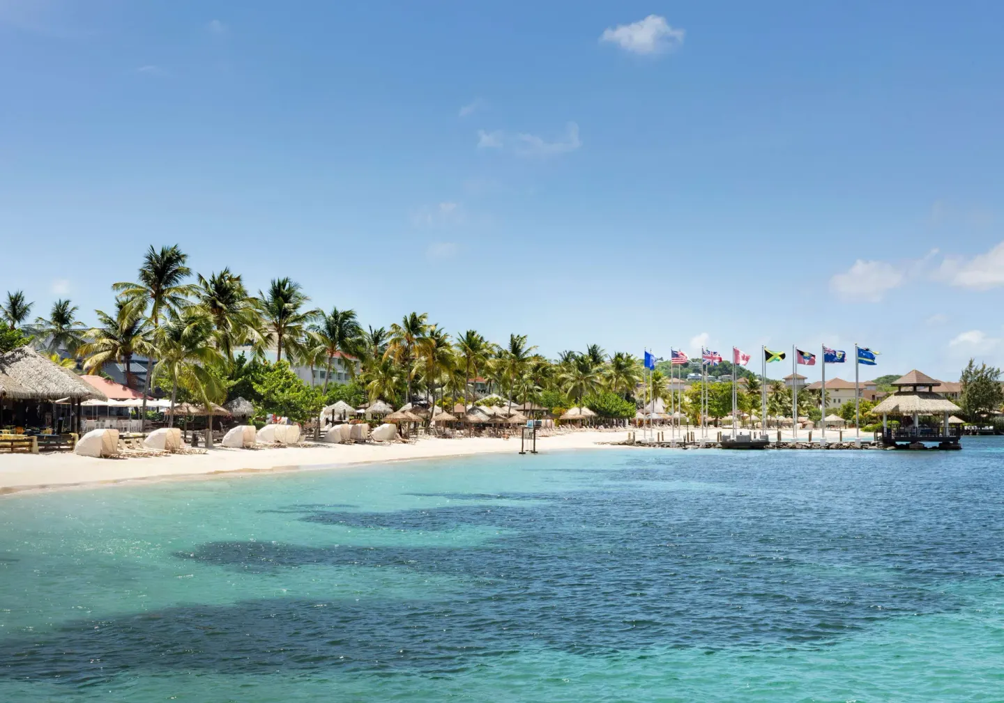 Palm-lined beach and turquoise water at Sandals Grande St. Lucian.