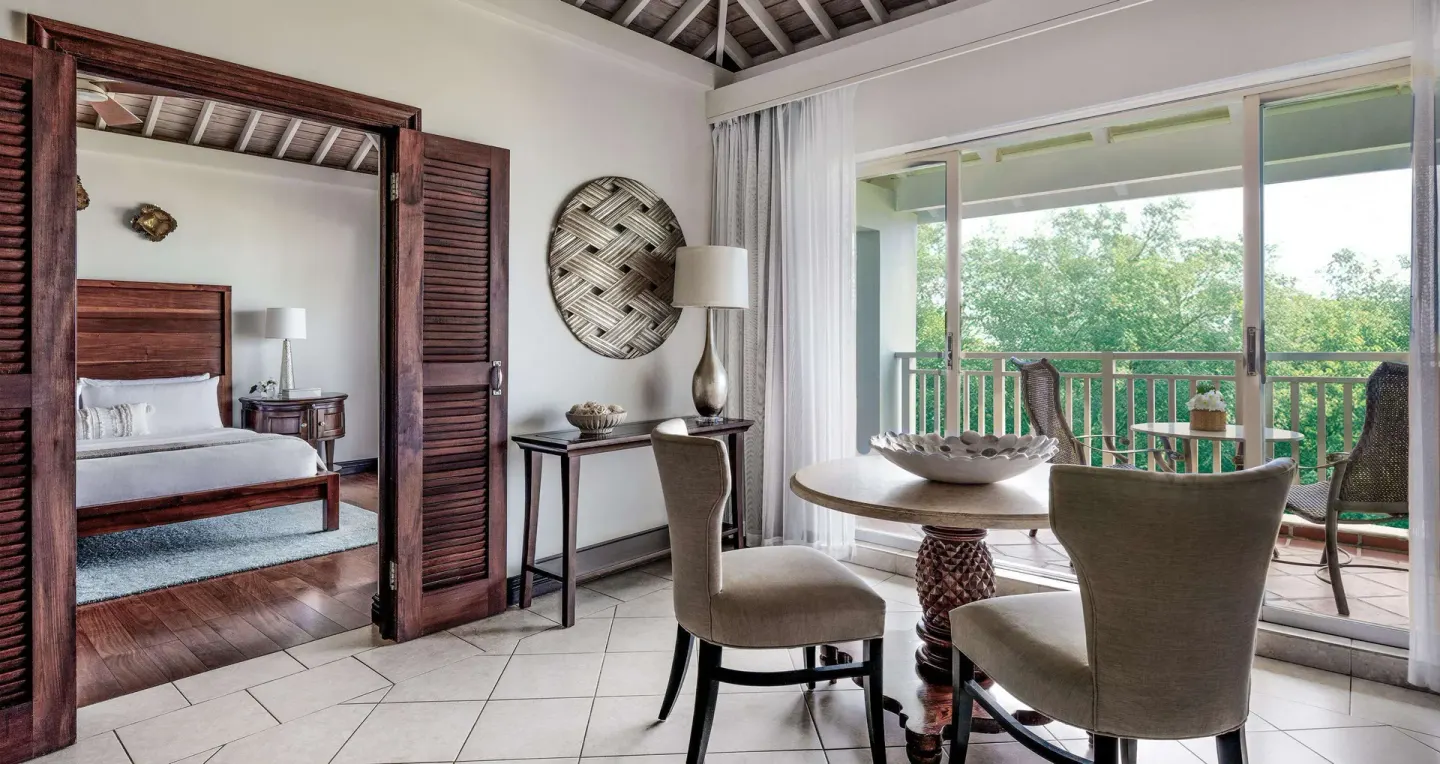Suite dining area with bedroom doorway and balcony at Sandals Grande St. Lucian.