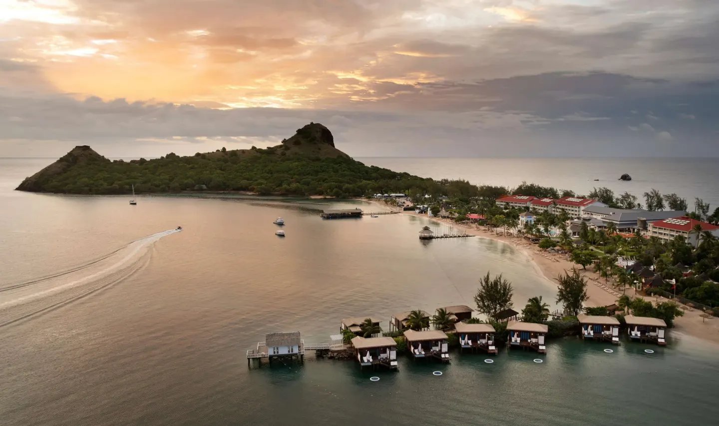 Sunset aerial view of the bay and overwater bungalows at Sandals Grande St. Lucian.