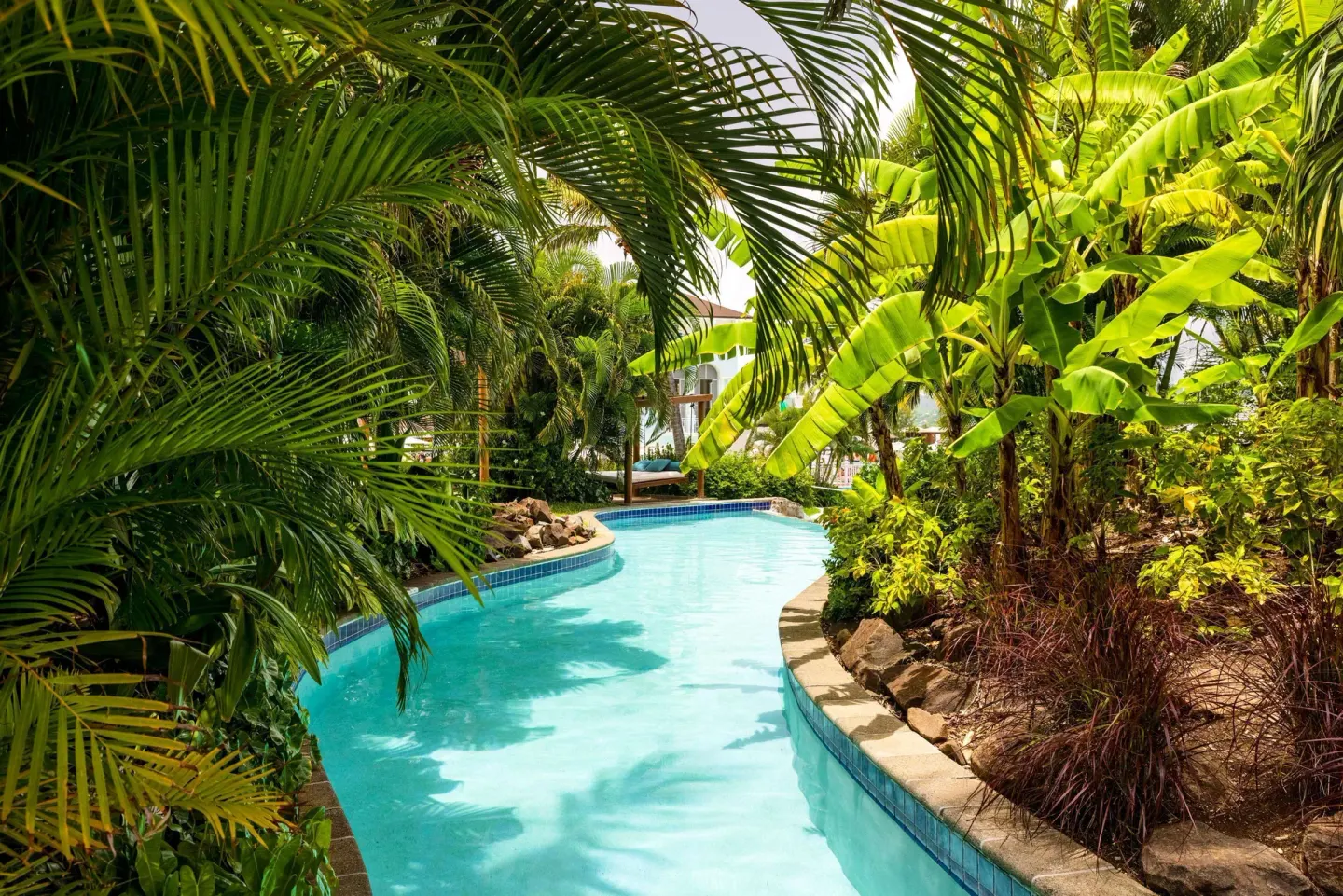 Tropical lagoon-style pool surrounded by palms at Sandals Grande St. Lucian.