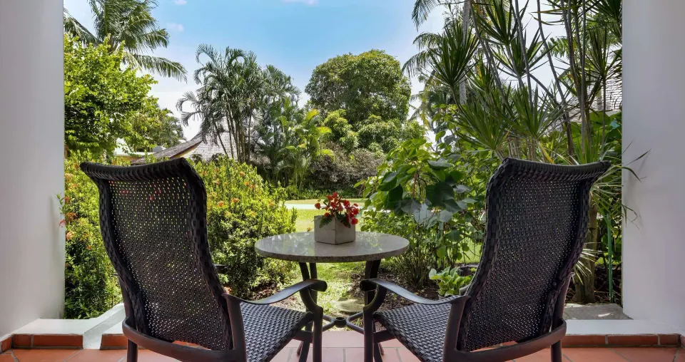 Garden patio with two chairs for a Caribbean Walkout Deluxe room at Sandals Grande St. Lucian.