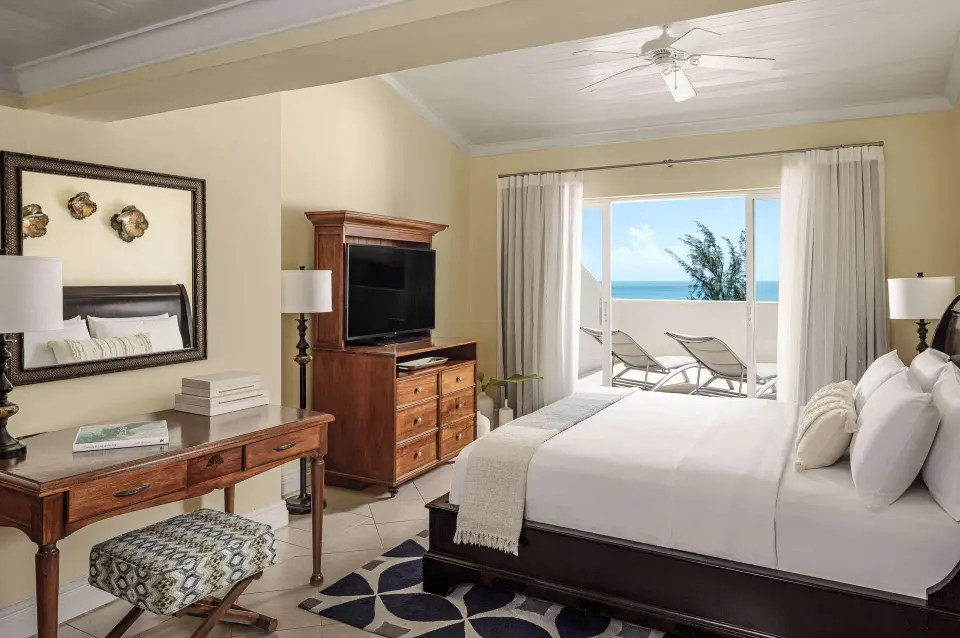 Luxury suite bedroom with king bed and balcony sea view at Sandals Grande St. Lucian.