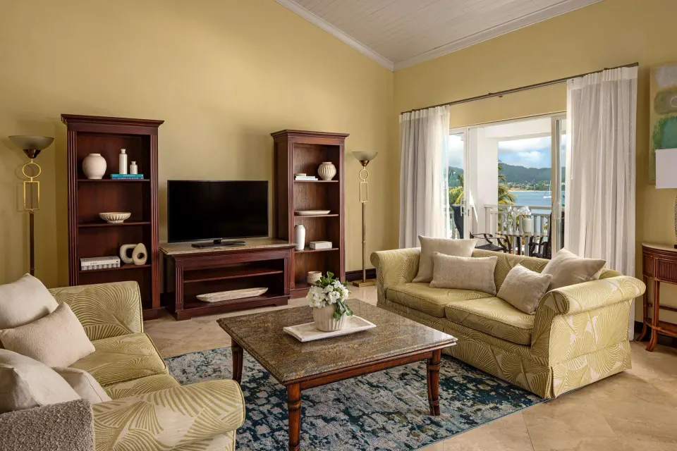 Luxury suite sitting room with sofas and balcony view at Sandals Grande St. Lucian.