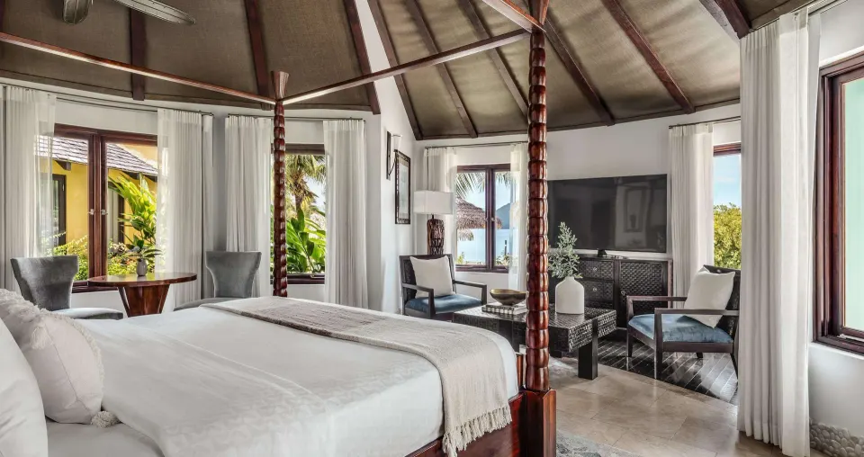Luxury rondoval suite bedroom with king bed and sitting area at Sandals Grande St. Lucian.