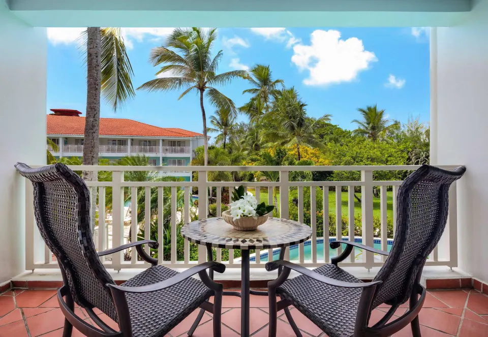 Balcony seating with garden and pool view at Sandals Grande St. Lucian.