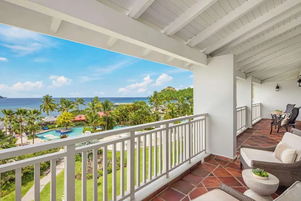 Covered balcony with ocean and resort views at Sandals Grande St. Lucian.