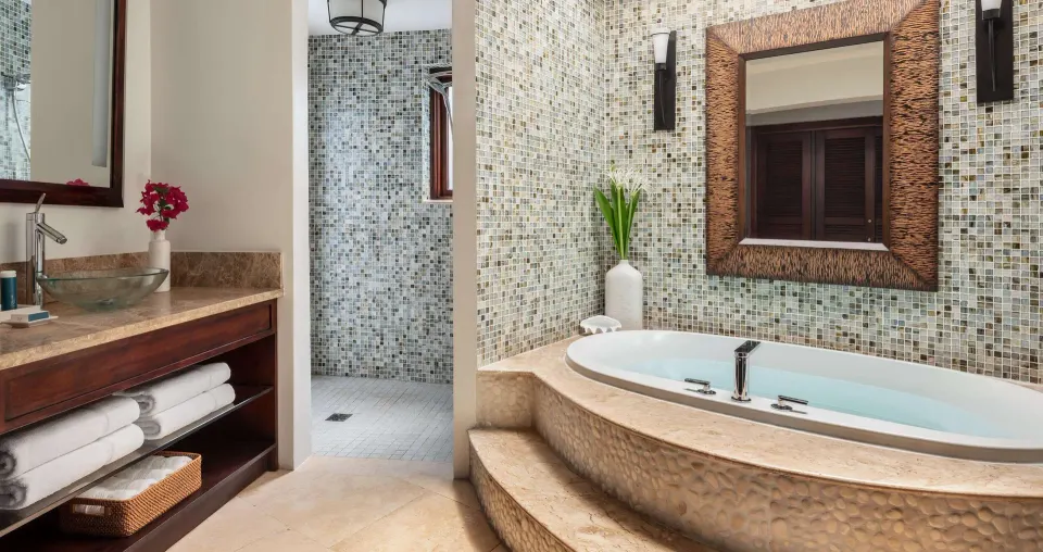Bathroom with oval soaking tub and vanity in a luxury suite at Sandals Grande St. Lucian.