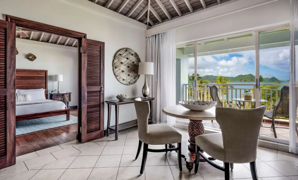 Ocean view one-bedroom suite sitting area and king bedroom at Sandals Grande St. Lucian.