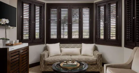 Guest room sitting area with louvered shutters at Sandals Grenada.