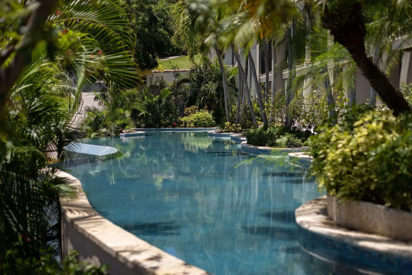 Quiet lagoon-style pool winding through tropical landscaping at Sandals Grenada.