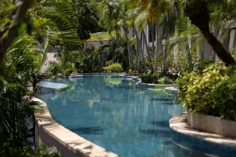 Quiet lagoon-style pool winding through tropical landscaping at Sandals Grenada.