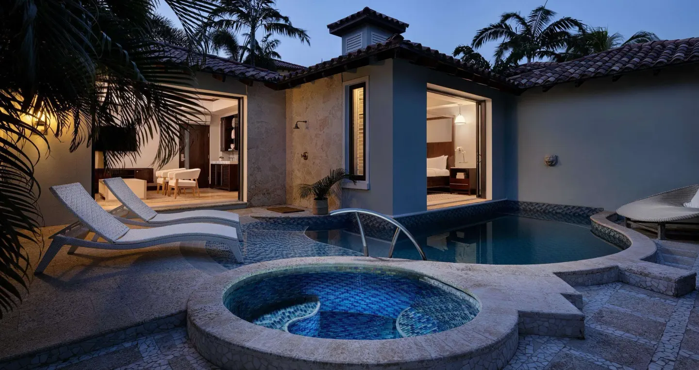 Private pool courtyard with spa, loungers, and lit suite interiors at Sandals Grenada.