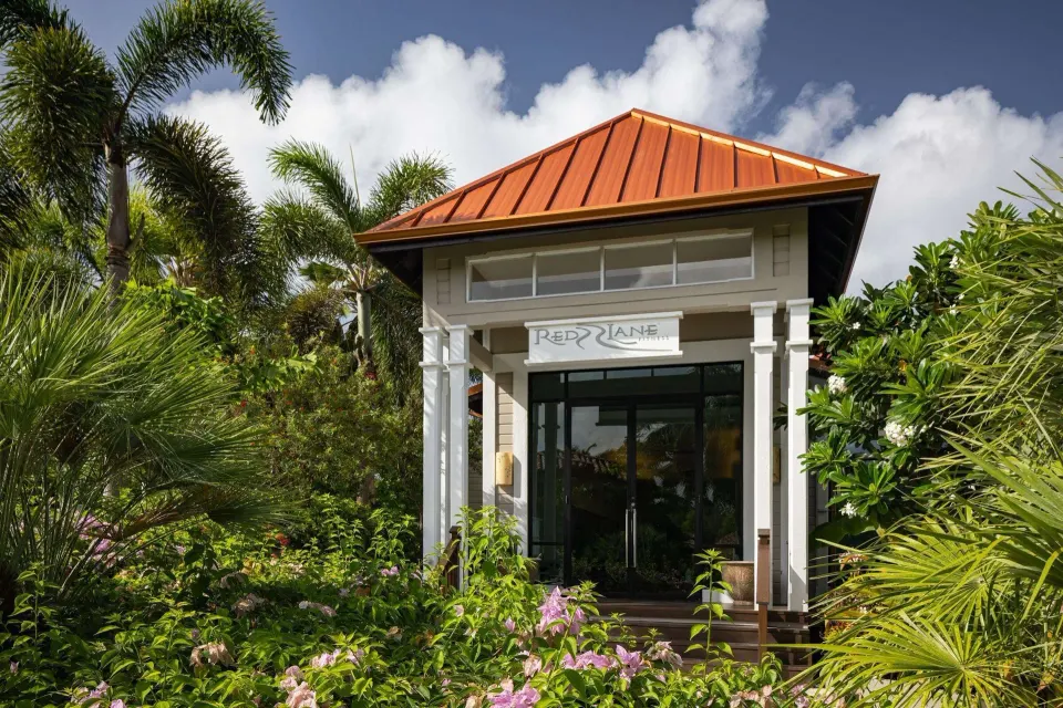 Spa entrance with tropical landscaping and a red roof at Sandals Grenada.