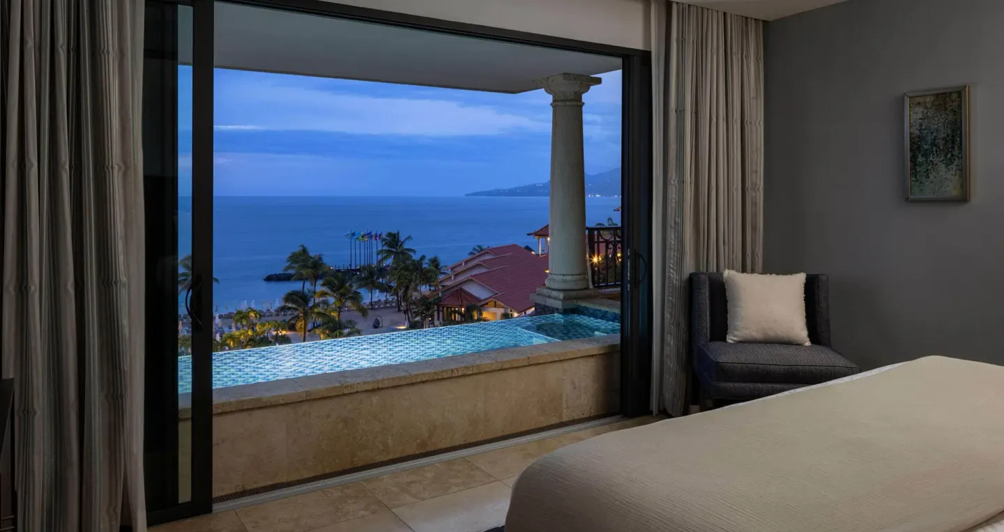 King bed guest room with plunge pool and twilight ocean view at Sandals Grenada.