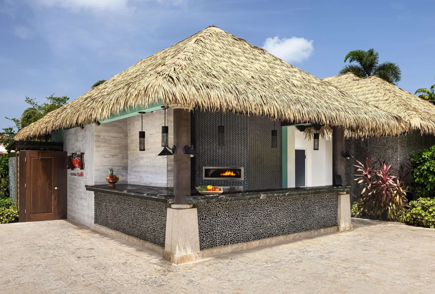 Thatched outdoor pizza counter with a visible oven at Sandals Grenada.
