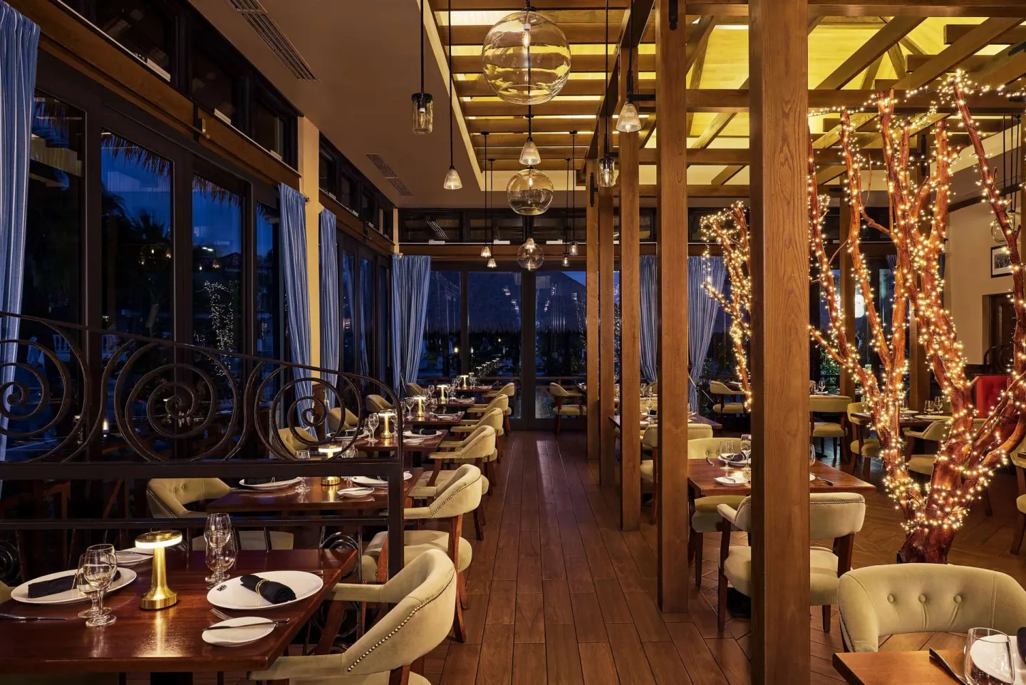 Elegant restaurant dining room with set tables and pendant lights at Sandals Grenada.