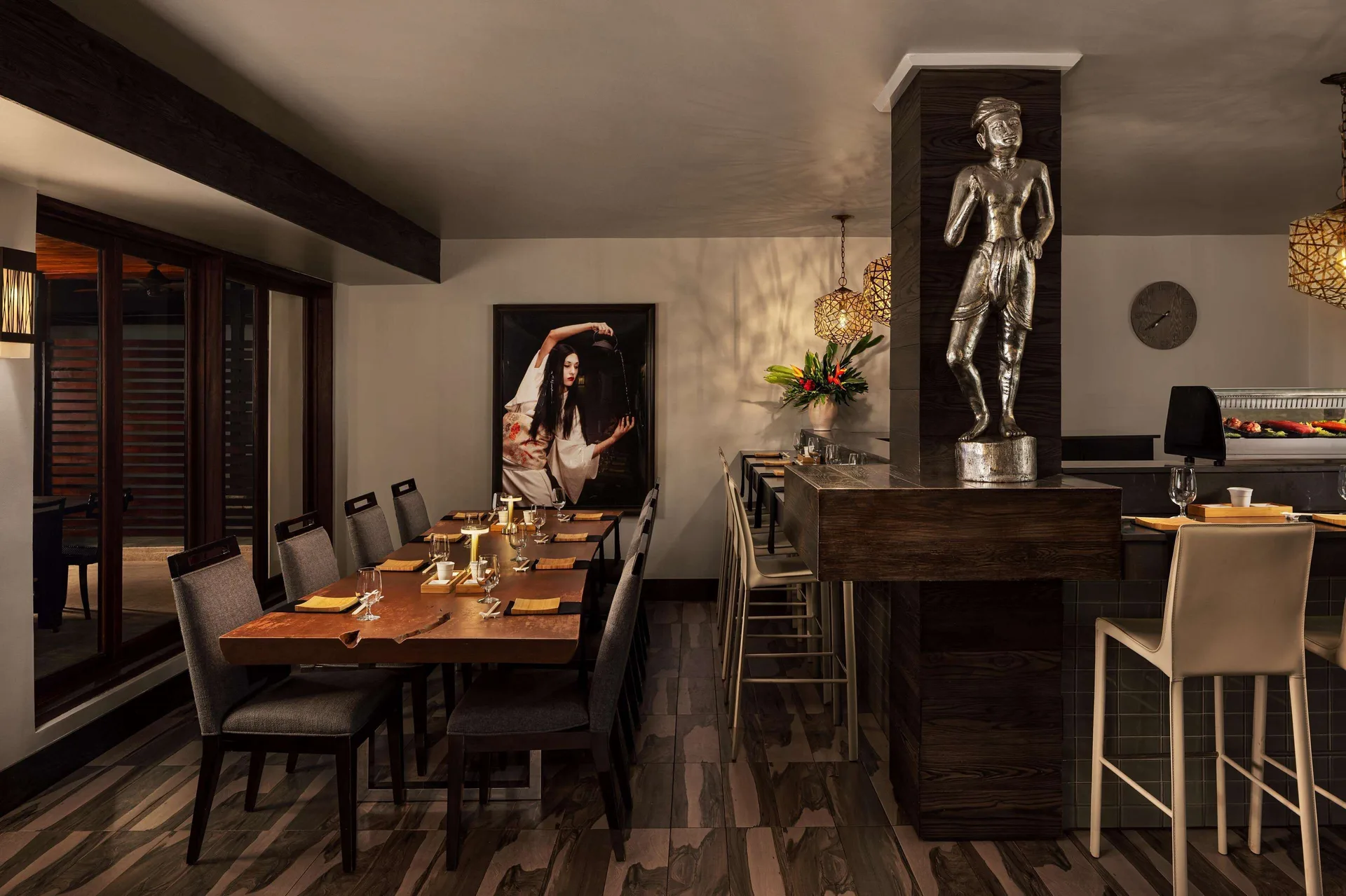 Japanese-style restaurant interior with tables, bar seating, and a statue at Sandals Grenada.