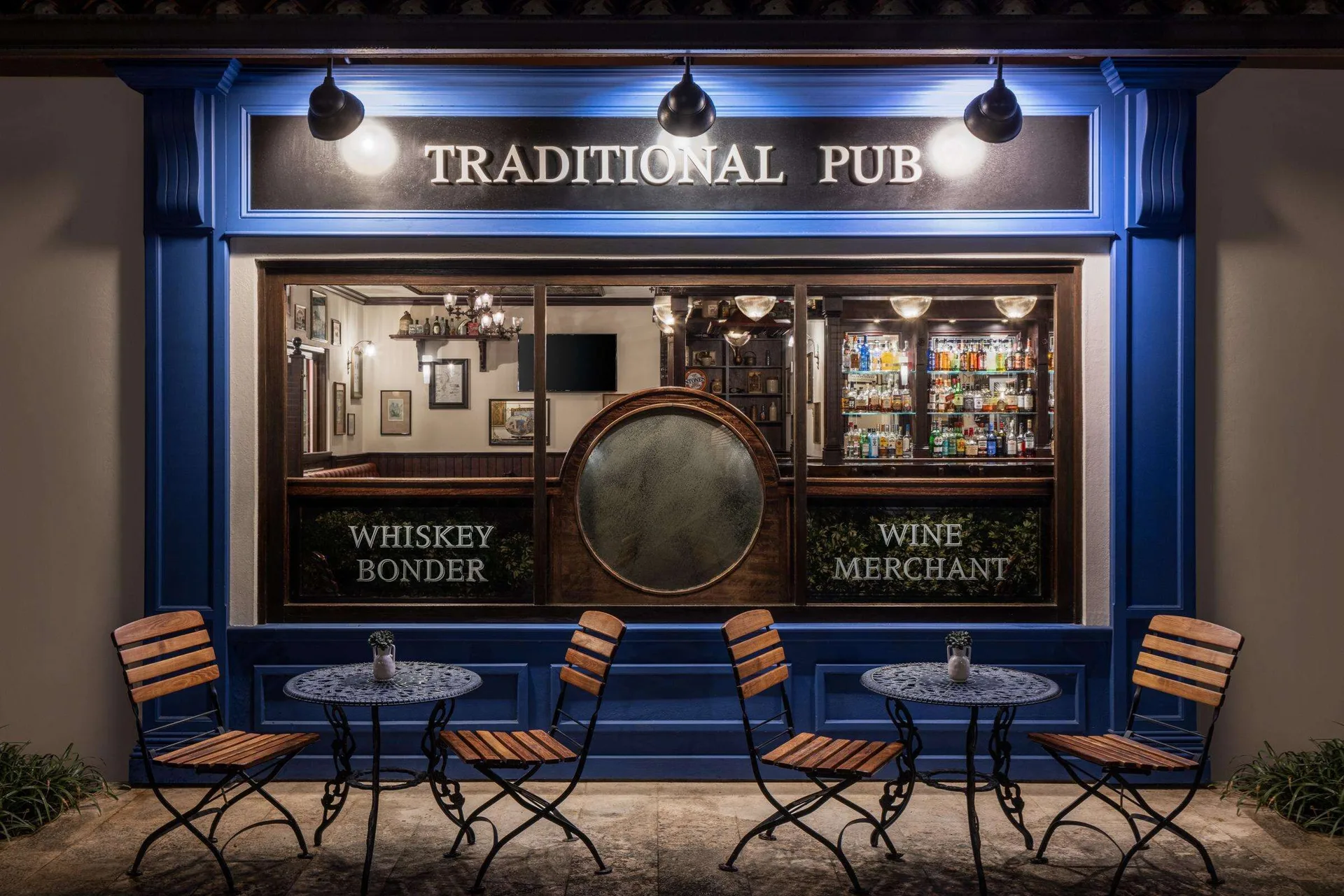 Traditional pub storefront with outdoor café tables at Sandals Grenada.