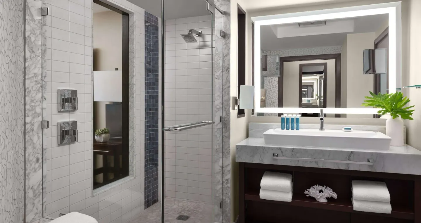 Modern suite bathroom with glass shower and vanity at Sandals Grenada.