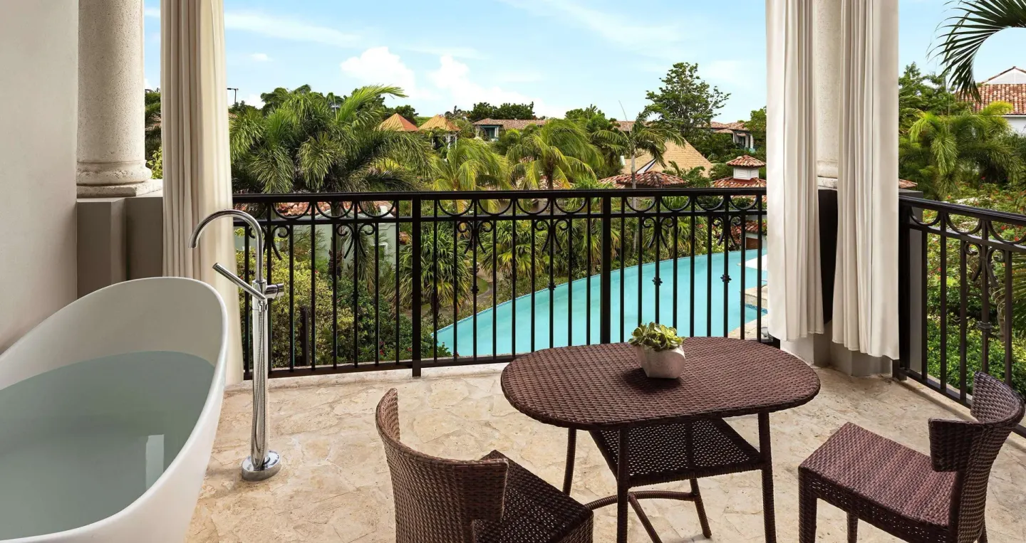South Seas junior suite balcony with soaking tub and pool view at Sandals Grenada.