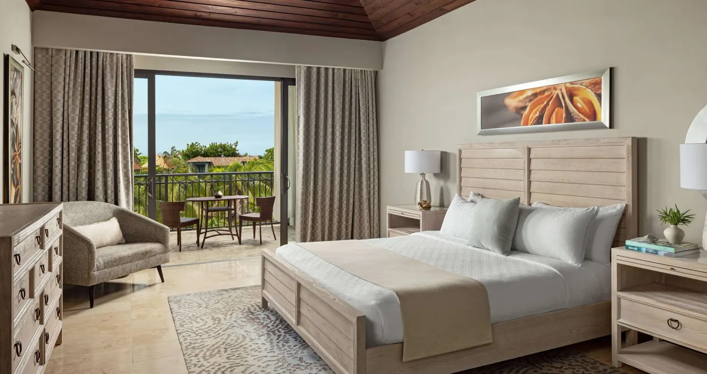 South Seas junior suite bedroom with balcony seating at Sandals Grenada.