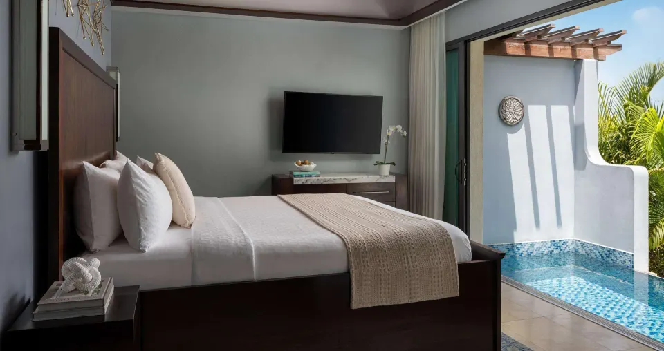King bed beside a private plunge pool in a Luxury Suite at Sandals Grenada.