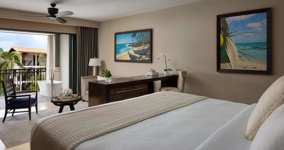 King bedroom with balcony soaking tub and garden views at Sandals Grenada.