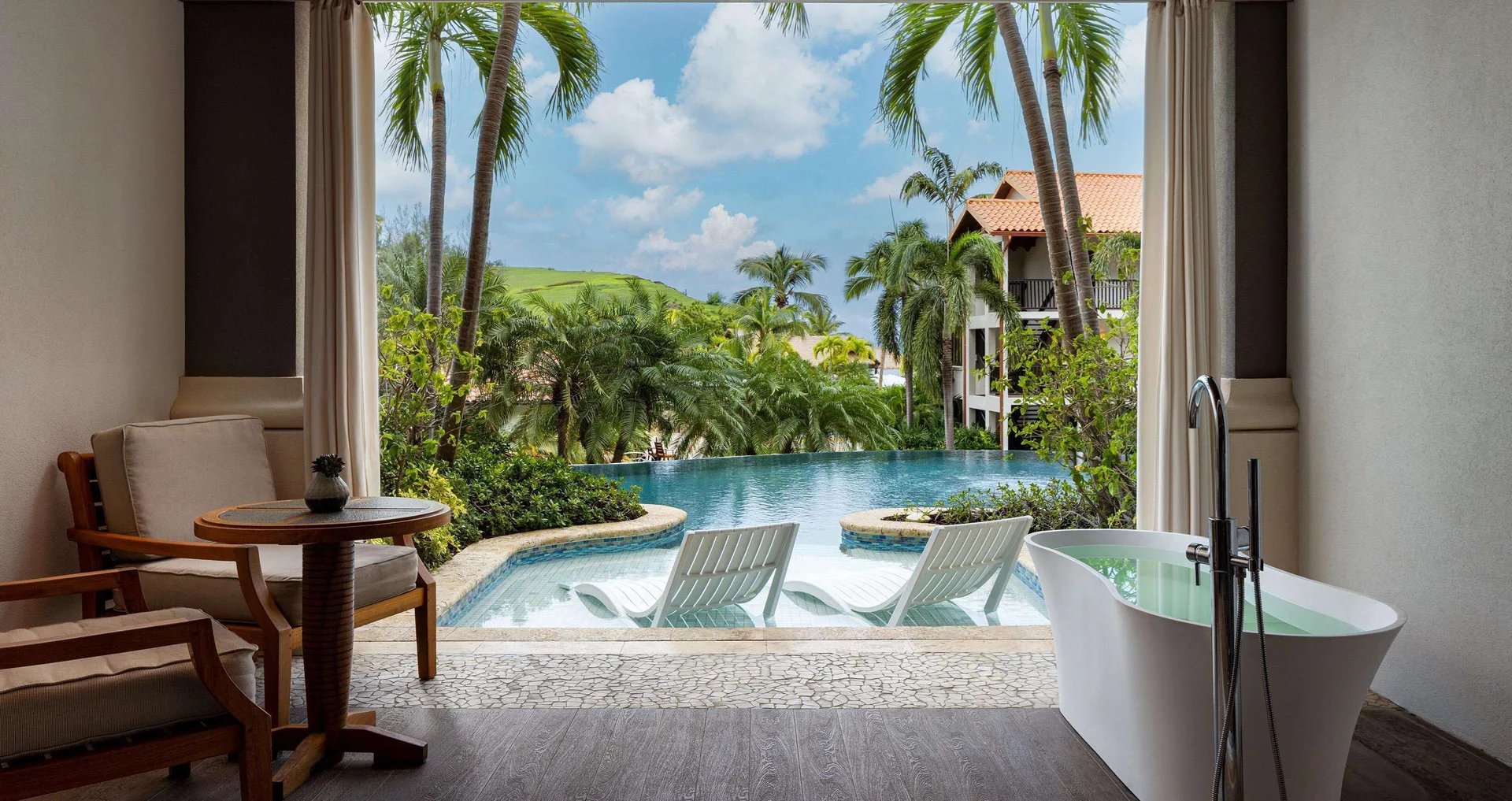 Swim-up suite patio with soaking tub and pool loungers at Sandals Grenada.