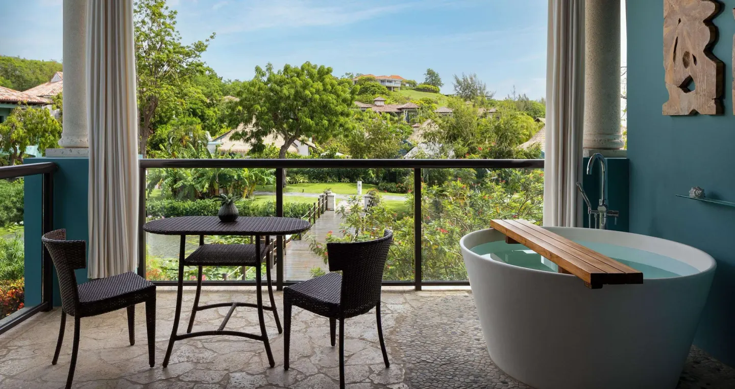 Lover's Hideaway Junior Suite balcony with soaking tub and garden view at Sandals Grenada.