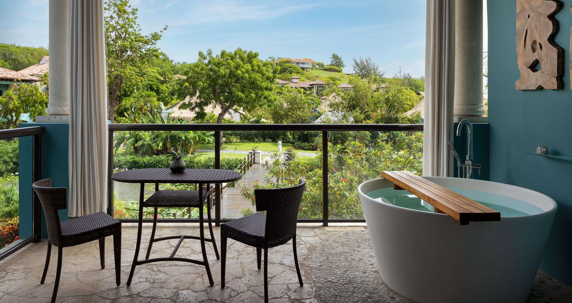 Lover's Hideaway Junior Suite balcony with soaking tub and garden view at Sandals Grenada.