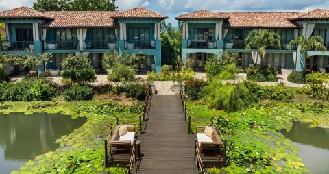 Lover's Hideaway Junior Suite exterior with lily pond and garden walkway at Sandals Grenada.