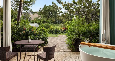 Romantic Suite patio with soaking tub and garden view at Sandals Grenada.