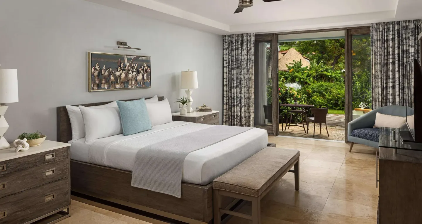 Romantic Suite bedroom with king bed and garden patio at Sandals Grenada.