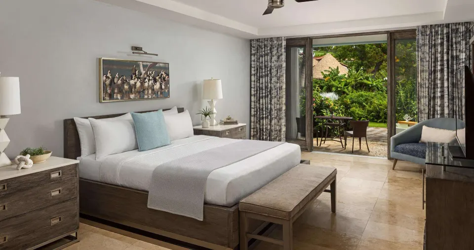 Romantic Suite bedroom with king bed and garden patio at Sandals Grenada.
